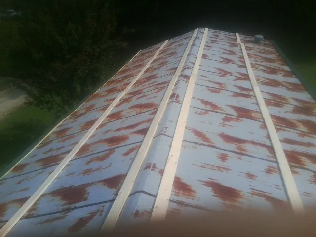 Rusted metal roof panels with new wood purlins before replacement — Storm Damage Roof Repair in Homerville by Roofing Brothers